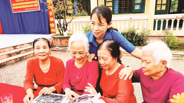Các cựu nữ dân quân lật giở những hình ảnh tư liệu quý về Trung đội dân quân gái Hoa Lộc.