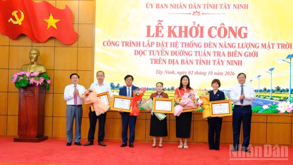 Bí thư Tỉnh ủy Tây Ninh Nguyễn Văn Quyết và Chủ tịch Ủy ban nhân dân tỉnh Lê Văn Hẳn trao hoa và bằng khen của Chủ tịch tỉnh cho 5 nhà tài trợ chương trình “Chung tay thắp sáng biên giới”. (Ảnh: THANH PHONG)