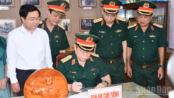 Đại tướng Nguyễn Trọng Nghĩa ghi cảm tưởng tại Nhà truyền thống Cơ quan Chính trị Quân khu 8. (Ảnh: THANH PHONG)