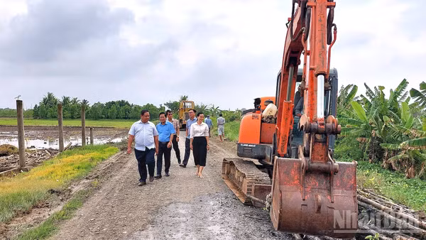 Lãnh đạo xã Tân Trụ trực tiếp kiểm tra tiến độ thi công mở rộng công trình giao thông nông thôn. (Ảnh: THANH PHONG)