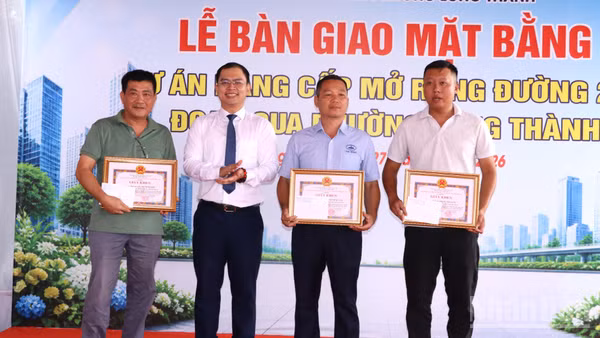Chủ tịch Ủy ban nhân dân phường Long Thành Lê Hoàng Sơn trao khen thưởng cho các hộ dân tiêu biểu trong bàn giao mặt bằng Dự án nâng cấp, mở rộng đường 25B. (Ảnh: THIÊN VƯƠNG)