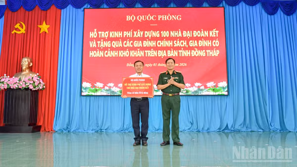 Đại tướng Nguyễn Tân Cương trao bảng tượng trưng của Bộ Quốc phòng hỗ trợ kinh phí xây dựng 100 nhà Đại đoàn kết trên địa bàn tỉnh Đồng Tháp. (Ảnh: CHÍ PHÚC)