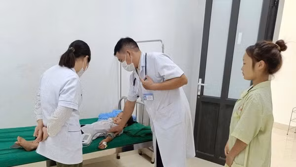 Bác sĩ ở Trung tâm Y tế Nậm Pồ khám, điều trị cho trẻ mắc bệnh quai bị. (Ảnh: LÊ LAN)