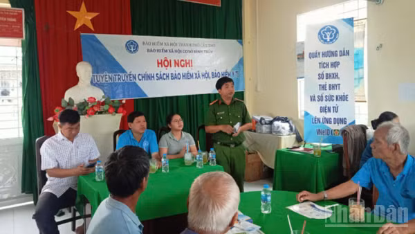 Bảo hiểm xã hội Cơ sở Bình Thủy lồng ghép tuyên truyền chính sách bảo hiểm xã hội, bảo hiểm y tế và hướng dẫn người dân tích hợp sổ bảo hiểm xã hội, thẻ bảo hiểm y tế trên ứng dụng VNeID. (Ảnh: LÊ THẢO)