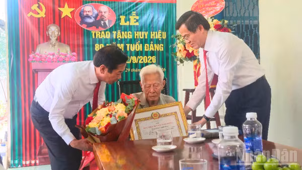 Đồng chí Đoàn Minh Huấn, Ủy viên Bộ Chính trị, Giám đốc Học viện Chính trị quốc gia Hồ Chí Minh cùng lãnh đạo thành phố Cần Thơ trao Huy hiệu 80 năm tuổi Đảng cho đồng chí Phạm Duy Khương. (Ảnh: VĂN ÚT)
