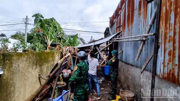 Cán bộ, chiến sĩ đồn Biên phòng Lai Hòa, Bộ đội Biên phòng thành phố Cần Thơ giúp dân khắc phục hậu quả lốc xoáy. (Ảnh: VĂN LONG)