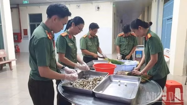 Cán bộ, chiến sĩ Phòng Tham mưu Công an thành phố Cần Thơ sơ chế nguyên liệu nấu cháo để kịp trao cho bà con vào buổi sáng. (Ảnh: HẢI ĐĂNG)