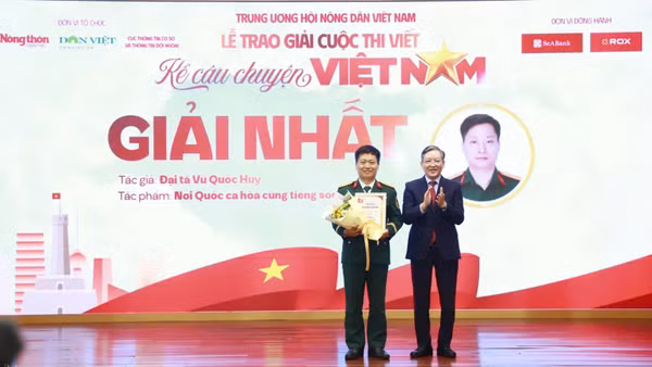 Ủy viên Trung ương Đảng, Phó Chủ tịch Ủy ban Trung ương Mặt trận Tổ quốc Việt Nam, Chủ tịch Trung ương Hội Nông dân Việt Nam Lương Quốc Đoàn trao giải Nhất cho tác giả Vũ Quốc Huy. (Ảnh: Phạm Hưng)