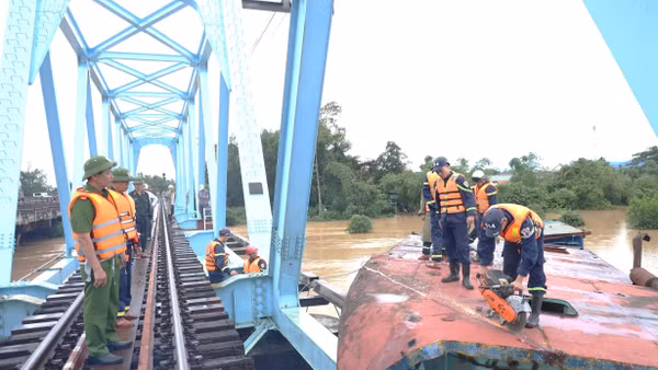 Lực lượng chức năng của Công an tỉnh Quảng Trị dùng thiết bị cắt sà-lan để cẩu ra khỏi khu vực cầu đường sắt.