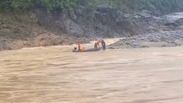 Lực lượng chức năng sử dụng xuồng máy tiếp cận khu vực hai người dân mắc kẹt, đưa họ về bờ. (Ảnh: địa phương cung cấp)