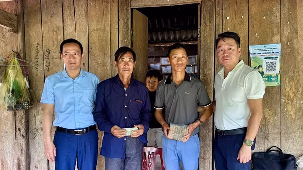 Đồng chí Nguyễn Tiến Thành (đầu tiên bên phải), Chủ tịch Ủy ban nhân dân xã Nậm Kè trao tiền dịch vụ môi trường rừng cho đại diện cộng đồng hai bản. (Ảnh: BÍCH HẠNH)