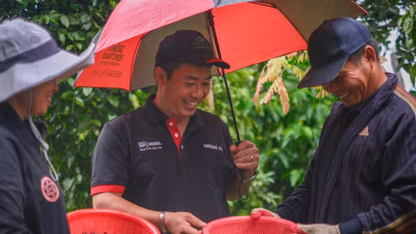 Anh Nguyễn Trọng Tường (giữa) đã có nhiều năm đồng hành cùng người trồng cà-phê - một hành trình hai chiều anh học hỏi từ kinh nghiệm của người nông dân, đồng thời chia sẻ những kiến thức thiết thực. (Ảnh: ILO/Linh Pham)