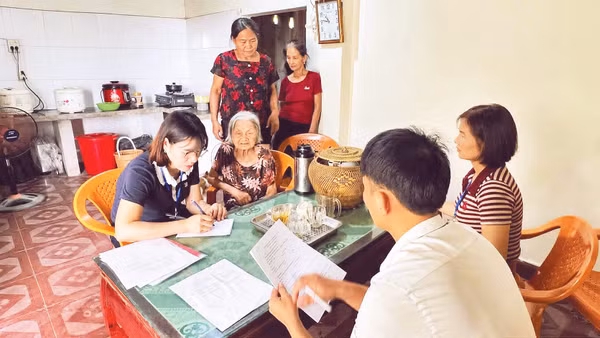 Cán bộ xã Đại Đồng đến tận nhà hỗ trợ người già yếu giải quyết thủ tục hành chính. Ảnh: Ngọc Anh