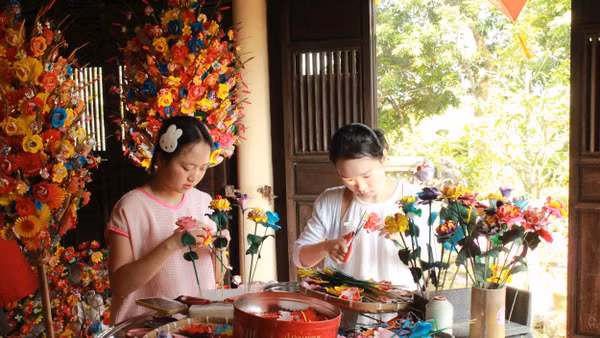 Du khách trải nghiệm tự làm hoa giấy.