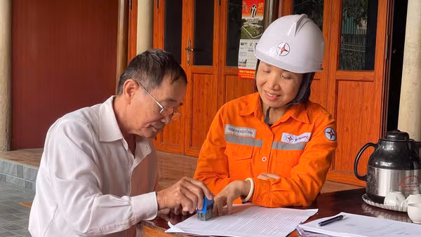 Cán bộ Điện lực Hương Sơn hướng dẫn khách hàng ký cam kết tiết kiệm điện.