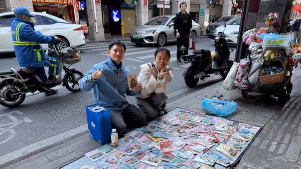 Tác giả (trái) bên một “sạp hàng” bán miếng dán tủ lạnh.
