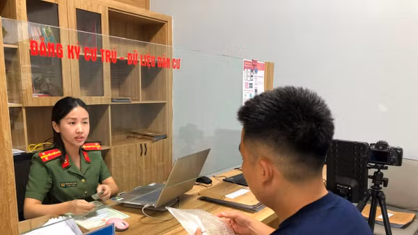 Cán bộ Công an phường Móng Cái 2 hướng dẫn người dân làm thủ tục hành chính.