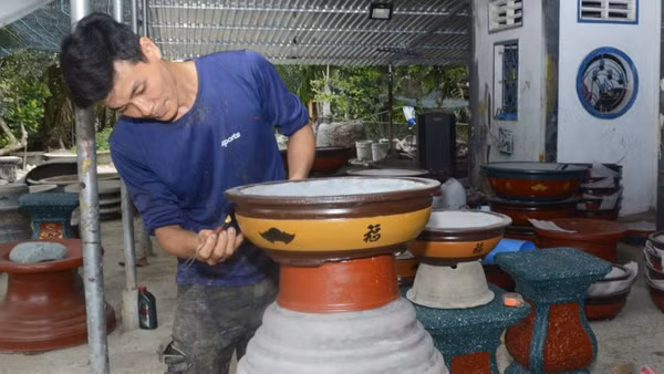 Gia đình anh Lê Hữu Lợi có nhiều thế hệ tham gia sản xuất chậu cây cảnh.