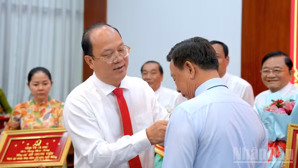 Đồng chí Nguyễn Hồ Hải, Ủy viên Trung ương Đảng, Bí thư Tỉnh ủy Cà Mau đeo Huy hiệu Đảng cho Đảng viên tại buổi lễ. (ảnh HỮU TÙNG).