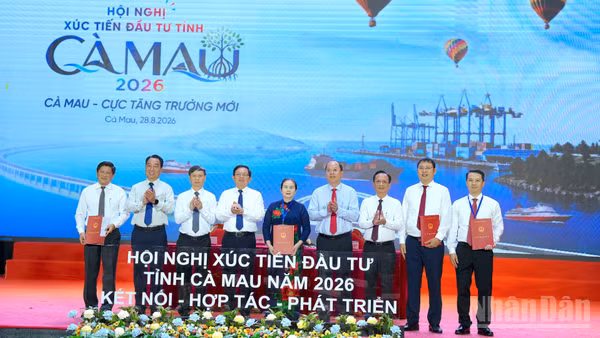 Lãnh đạo tỉnh Cà Mau trao biên bản ghi nhớ cho các nhà đầu tư trước sự chứng kiến của Phó Thủ tướng Chính phủ Hồ Quốc Dũng (thứ 4 từ trái qua) và Bí thư Tỉnh ủy Cà Mau Nguyễn Hồ Hải (thứ 4 từ phải qua). (Ảnh: HỮU TÙNG)