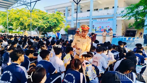 Cán bộ Phòng Cảnh sát giao thông Công an tỉnh Cà Mau phát tờ rơi tuyên truyền cho các em học sinh tại trường Trung học phổ thông Sông Đốc (xã Sông Đốc, tỉnh Cà Mau).