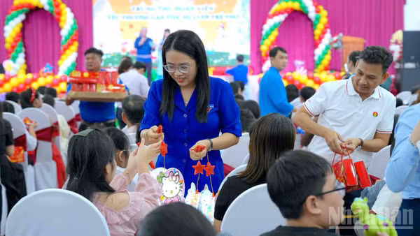 Tặng quà cho các cháu thiếu nhi là con công nhân, viên chức, lao động tại buổi họp mặt. (Ảnh: HỮU TÙNG)