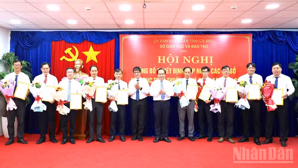 Phó Chủ tịch Ủy ban nhân dân tỉnh Cà Mau Nguyễn Minh Luân (thứ 6 từ phải qua) trao quyết định bổ nhiệm và tặng hoa các Hiệu trưởng Trường trung học phổ thông thuộc Sở Giáo dục và Đào tạo tỉnh. (Ảnh: HỮU TÙNG)
