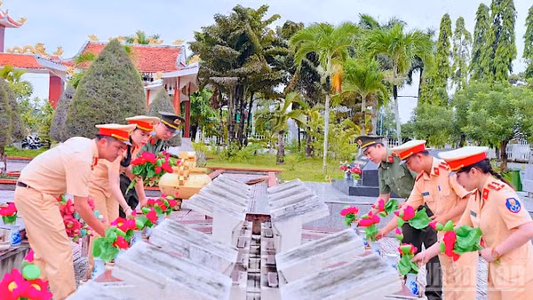 Cán bộ, chiến sĩ Công an Cà Mau chỉnh trang, dọn dẹp vệ sinh và thay mới hoa sen tại Nghĩa trang liệt sĩ tỉnh.