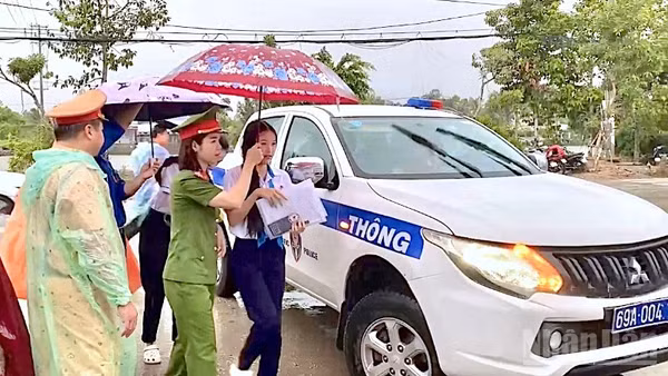 Lực lượng Cảnh sát giao thông Công an tỉnh Cà Mau sử dụng xe chuyên dụng chở các em học sinh đến điểm thi đúng giờ trong lúc trời mưa vào sáng 11/6.