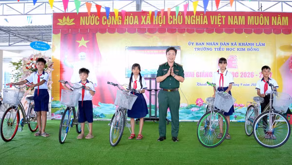 Đại tá Phạm Minh Giang, Bí thư Đảng ủy, Chính ủy Bộ đội Biên phòng Cà Mau, tặng xe đạp động viên các em học sinh tại Trường tiểu học Kim Đồng (xã Khánh Lâm, tỉnh Cà Mau). (Ảnh: HOÀNG TÁ)