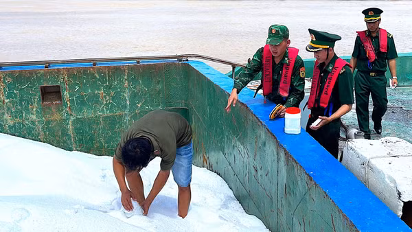 Lấy mẫu số phân urê trên sà lan LA-08708 giám định theo quy định của pháp luật. (Ảnh: HOÀNG TÁ)