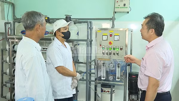 Anh Trần Văn Được bên cơ sở sản xuất nước tinh khiết của gia đình. (Ảnh: KIỀU DUYÊN)