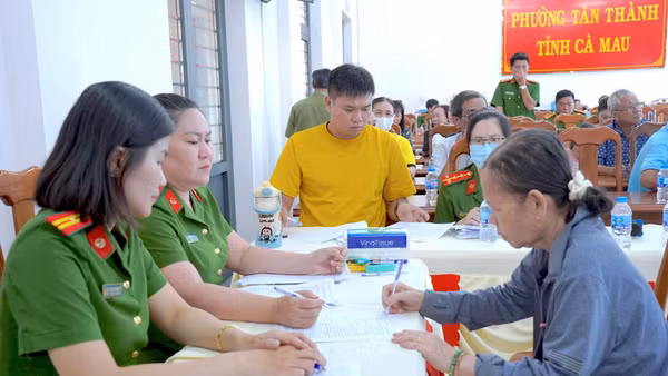 Cán bộ phòng Cảnh sát Quản lý hành chính về Trật tự xã hội Công an tỉnh Cà Mau thu nhận thông tin thân nhân liệt sĩ chưa xác định danh tính tại điểm phường Tân Thành. (ảnh HỮU ĐỆ).