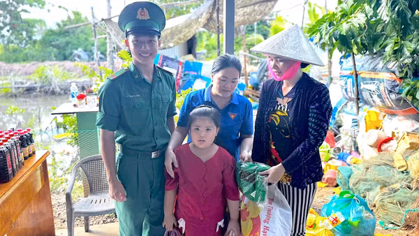 Cán bộ, chiến sĩ Đồn Biên phòng Rạch Gốc và Đoàn thanh niên địa phương đổi rác lấy quà cho người dân. (ảnh HOÀNG TÁ).