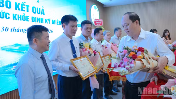 Đồng chí Nguyễn Hồ Hải, Ủy viên Trung ương Đảng, Bí thư Tỉnh ủy Cà Mau (bìa phải) trao tặng hoa và Bằng khen của Chủ tịch Ủy ban nhân dân tỉnh cho các tập thể tiêu biểu, xuất sắc tham gia thực hiện Nghị quyết 72 của Bộ Chính trị tại địa phương. (Ảnh: HỮU TÙNG)