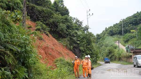 Công nhân điện lực Lào Cai kiểm tra một điểm sạt lở trên địa bàn phường Yên Bái.