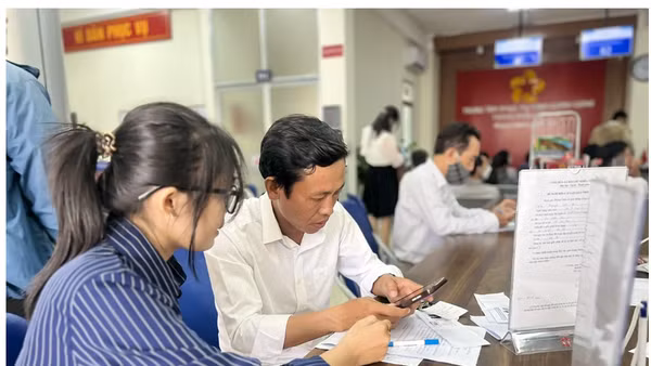Hỗ trợ người dân làm thủ tục nộp hồ sơ trực tuyến tại Trung tâm phục vụ hành chính công Cần Thơ. Ảnh: MINH HUYỀN