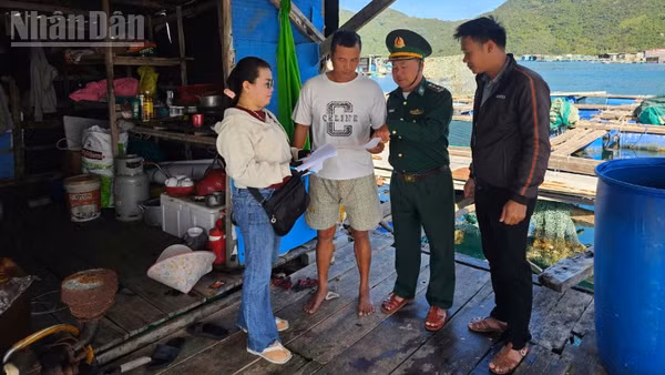 Cán bộ Đồn Biên phòng An Hải cùng các chủ phương tiện và ngư dân trao đổi, hướng dẫn kê khai, rà soát hồ sơ tàu cá tại lồng bè. (Ảnh: THÙY DUNG)