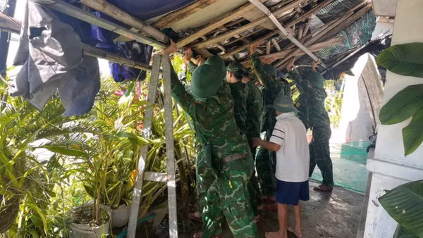 Cán bộ, chiến sĩ Đồn Biên phòng Xuân Đài giúp dân khắc phục hậu quả sau bão số 13.