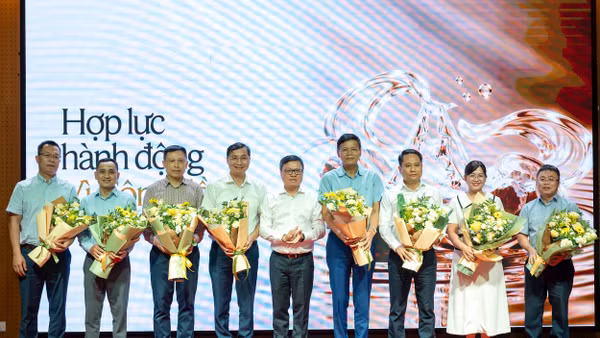 Đồng chí Lê Quốc Minh tặng hoa cho đại diện một số cơ quan báo chí, tổ chức truyền thông sẽ tham gia không gian thông tin chung về hoạt động vì cộng đồng. Ảnh: Thủy Nguyên