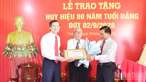 Đồng chí Huỳnh Long Tòa (giữa), Chi bộ ấp Nô Công, Đảng bộ xã Cầu Ngang, tỉnh Vĩnh Long nhận Huy hiệu 80 năm tuổi Đảng. (Ảnh: MINH KHỞI)