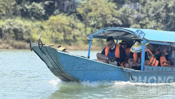 Khách du lịch trải nghiệm dịch vụ tàu vào hang động Phong Nha-Kẻ Bàng, Quảng Trị. (Ảnh: HNV)