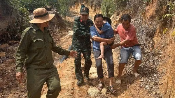 Các lực lượng chức năng đưa cháu K xuống núi, về với gia đình. (Ảnh: CTV)