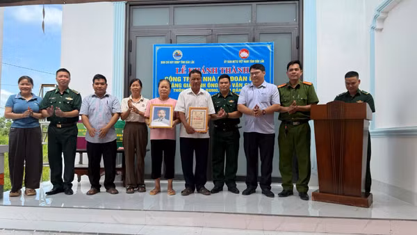 Đại diện Ban Chỉ huy Bộ đội Biên phòng tỉnh Đắk Lắk và cấp ủy, chính quyền địa phương, cùng các đơn vị tặng ảnh Bác Hồ và biểu trưng Nhà Đại đoàn kết cho gia đình ông Ngô Văn Giáp. (Ảnh: NGUYỄN LÂN)