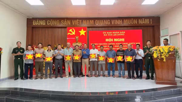 Đại diện các đơn vị và địa phương trao cờ Tổ quốc tặng các ngư dân tại xã Tuy An Đông. (Ảnh: Ngọc Lân)