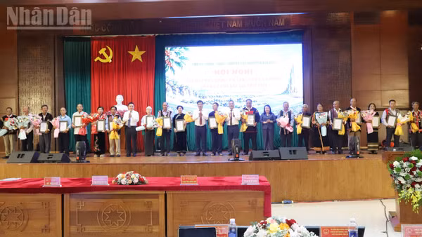 Lãnh đạo tỉnh Đắk Lắk trao giấy chứng nhận và tặng hoa chúc mừng các già làng, người có uy tín tiêu biểu. (Ảnh: CÔNG LÝ)