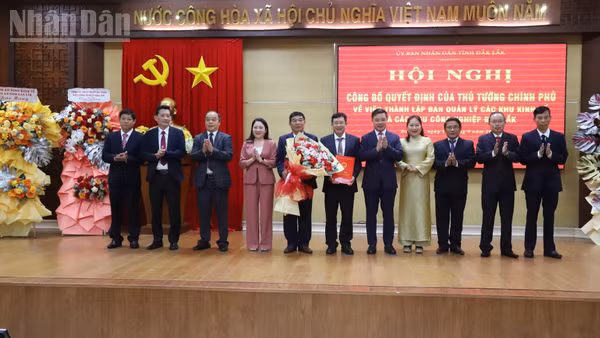 Chủ tịch Ủy ban nhân dân tỉnh Đắk Lắk Đỗ Hữu Huy trao Quyết định của Thủ tướng Chính phủ thành lập Ban Quản lý các khu kinh tế và các khu công nghiệp Đắk Lắk và tặng hoa chúc mừng. (Ảnh: Công Lý)