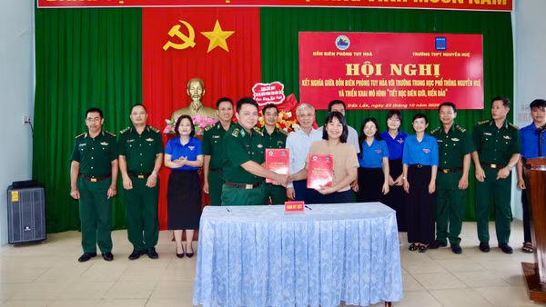 Đại diện chỉ huy Đồn Biên phòng Tuy Hòa và Trường trung học phổ thông Nguyễn Huệ ký chương trình kết nghĩa. (Ảnh: NGUYỄN LÂN)
