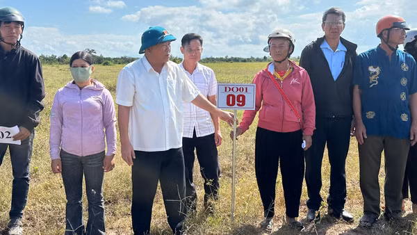 Lãnh đạo Ủy ban nhân dân xã Ia Rvê giao đất cho người dân ngoài thực địa. (Ảnh: TRUNG HẢI)