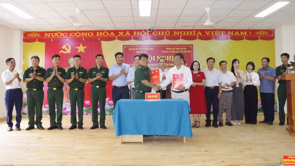 Lãnh đạo Ban Chỉ huy Bộ đội Biên phòng tỉnh Đắk Lắk và Trường phổ thông nội trú tiểu học và trung học cơ sở Buôn Đôn trao biên bản ký kết kết nghĩa. (Ảnh: DÂN QUÂN)